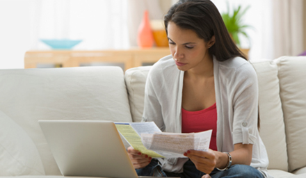 Woman reviewing how to pay off debt with bills in hand