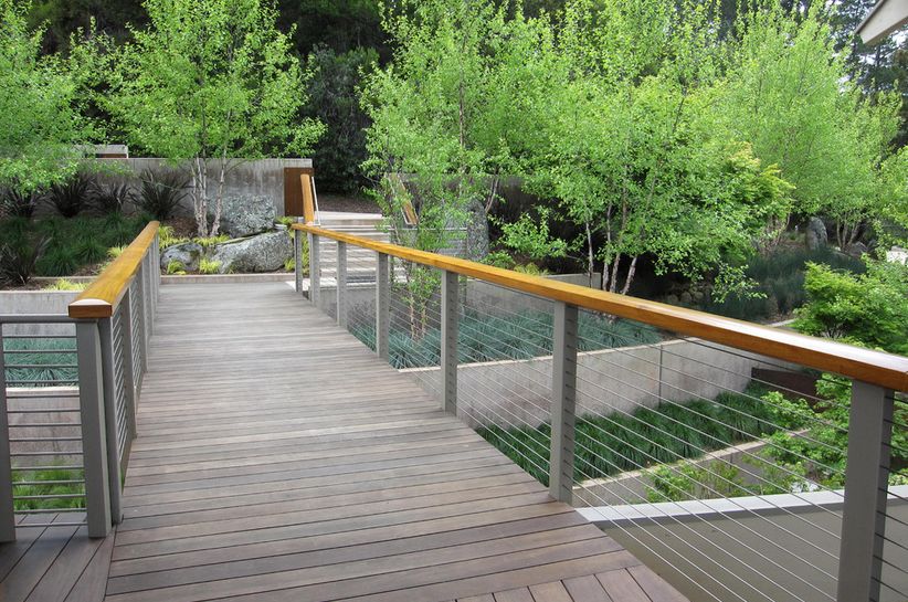 Modern backyard bridge with cable railings