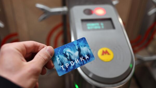 Пассажир с картой Тройка проходит через турникет на станции метро Сходненская в Москве