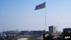 An enormous Azerbaijani flag flies above the construction site of the Crystal Hall on the Caspian shoreline in Baku earlier this year.