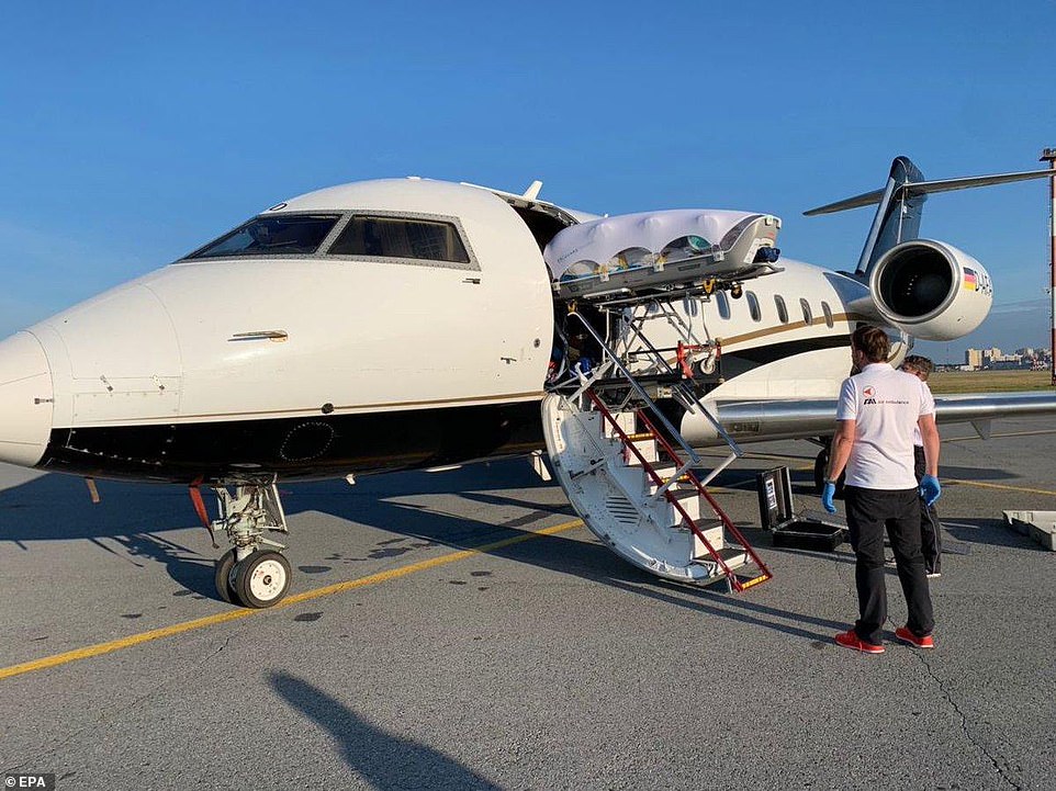 A plane carrying Russian opposition leader Alexei Navalny (pictured being lifted onto the plane) who is in a coma after a suspected poisoning left for a German hospital on Saturday