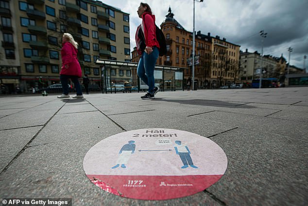 Instead of implementing a lockdown, Sweden focused on voluntary measures and offered guidance for social distancing and hygiene. Pictured: A sticker on the floor in Stockholm asks people to stand two meters apart