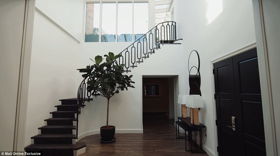 A sweeping staircase leads to a conservatory and outdoor terrace area 