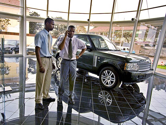 Disposable income: Two young Angolan men in a car dealership selling Range Rovers. Despite the flush of wealth, two thirds of the country