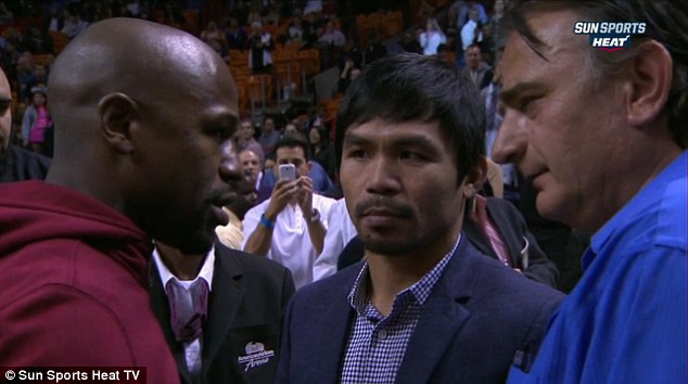 Mayweather and Pacquiao (centre) were pictured together for the first time at the NBA game - the man on the right of the shot is the Filipino fighter