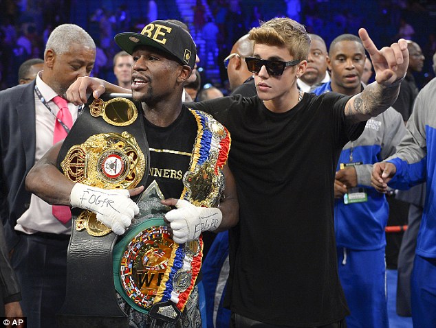 The American poses for photos with singer Justin Bieber after defeating Alvarez in Las Vegas