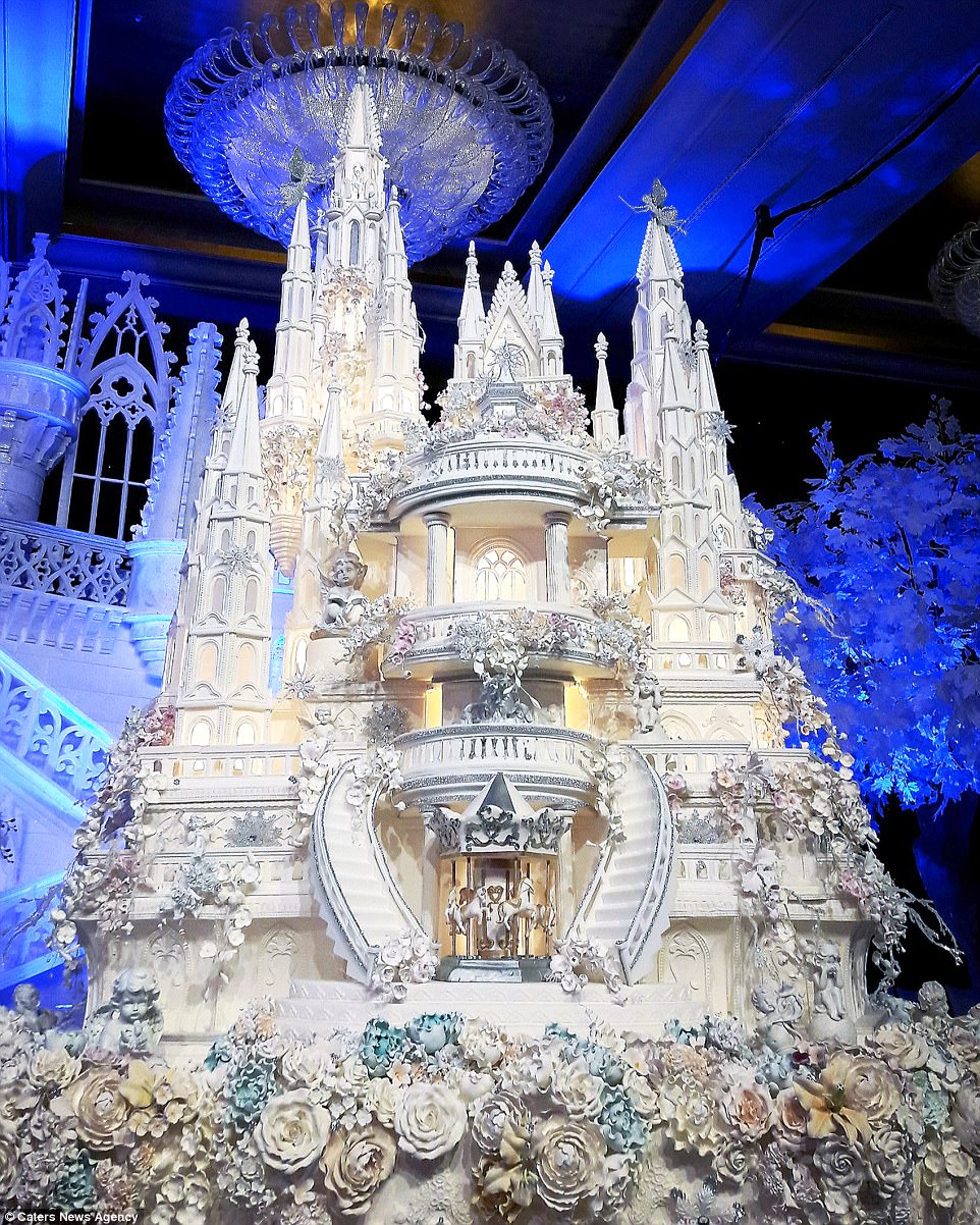 This fairytale castle wedding cake features incredible sugar work detail, including a carousel of horses and hundreds of flowers