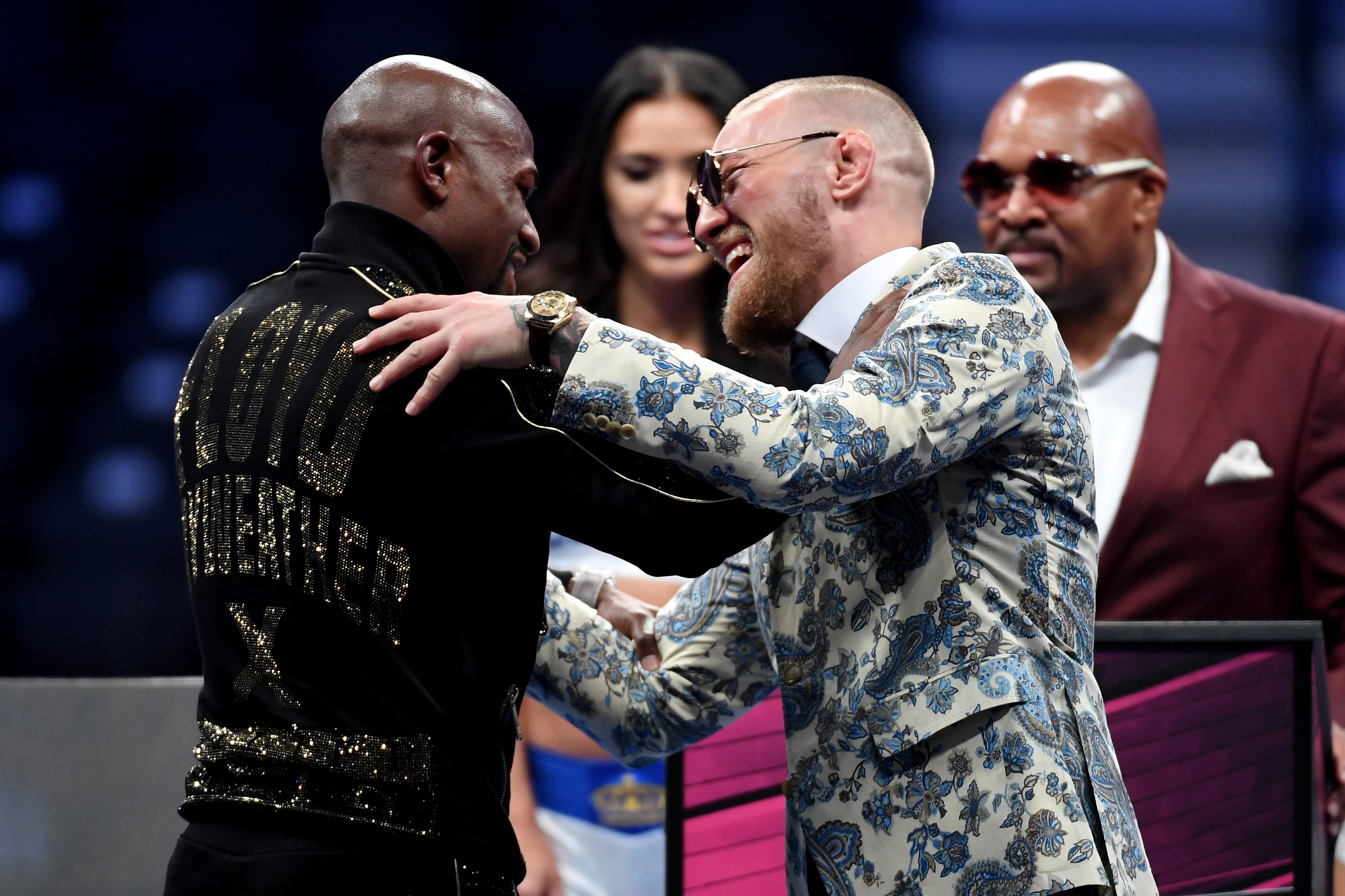 (L-R) Floyd Mayweather Jr. and Conor McGregor shake hands after Mayweather
