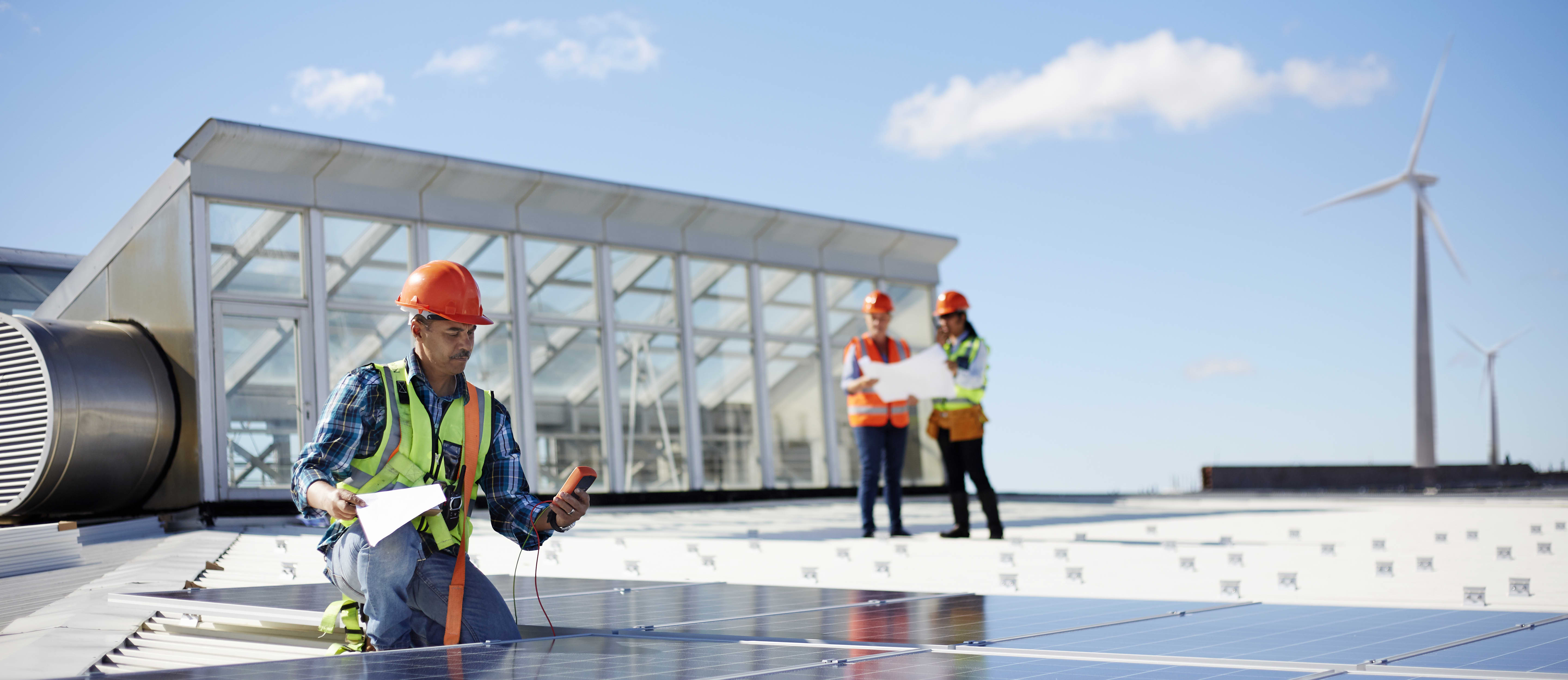 A group of engineers in hard hats test solar panels