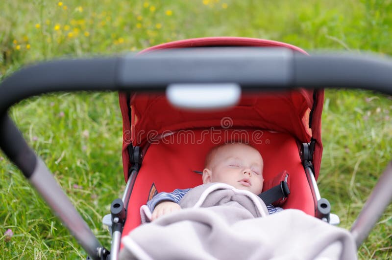 Baby sleeping in stroller. Sweet little baby boy sleeping in stroller royalty free stock images