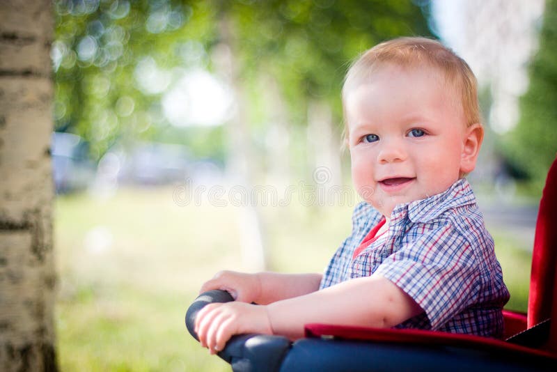 Baby in stroller. Smiling baby sitting in a stroller royalty free stock photo