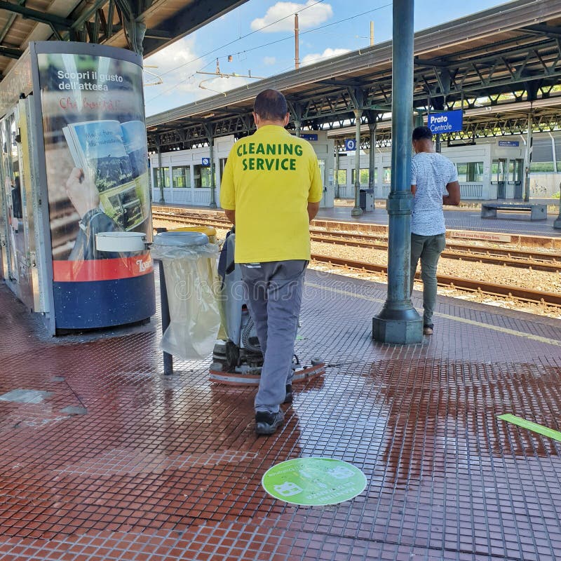 Cleaning operative cleaning the floor at a train station platform in Italy. August 2020. royalty free stock photography