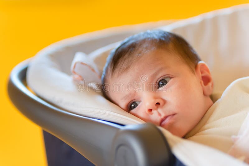 Cute baby in a stroller. With yellow background royalty free stock photography