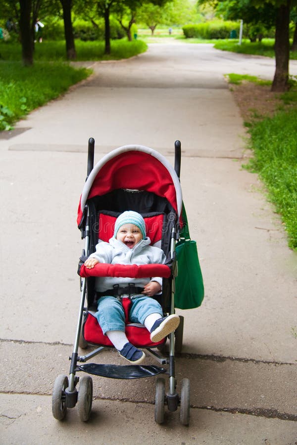 Happy baby in stroller. Outdoors in a park royalty free stock photography