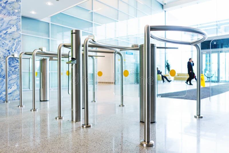 Stylish turnstiles made of glass and metal in the lobby of an unrecognizable business center. Modern control and security systems. Access system in an office royalty free stock photo