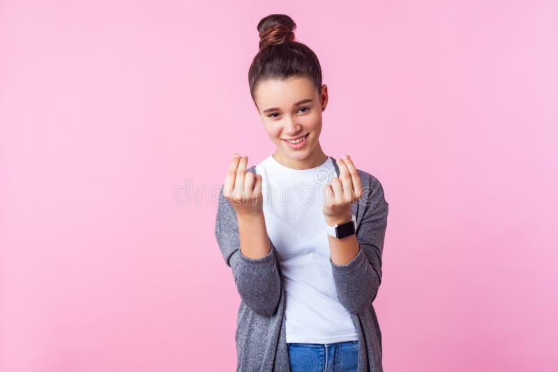 Portrait of sly brunette girl showing money gesture, teenager demanding more allowance. studio shot isolated on pink background. Portrait of sly brunette girl royalty free stock image