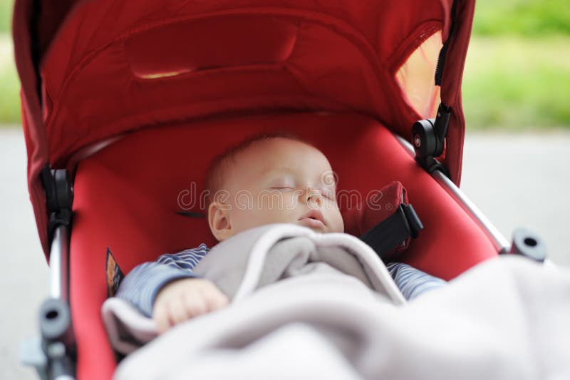 Sweet baby in stroller. Sweet little baby boy sleeping in stroller royalty free stock photos