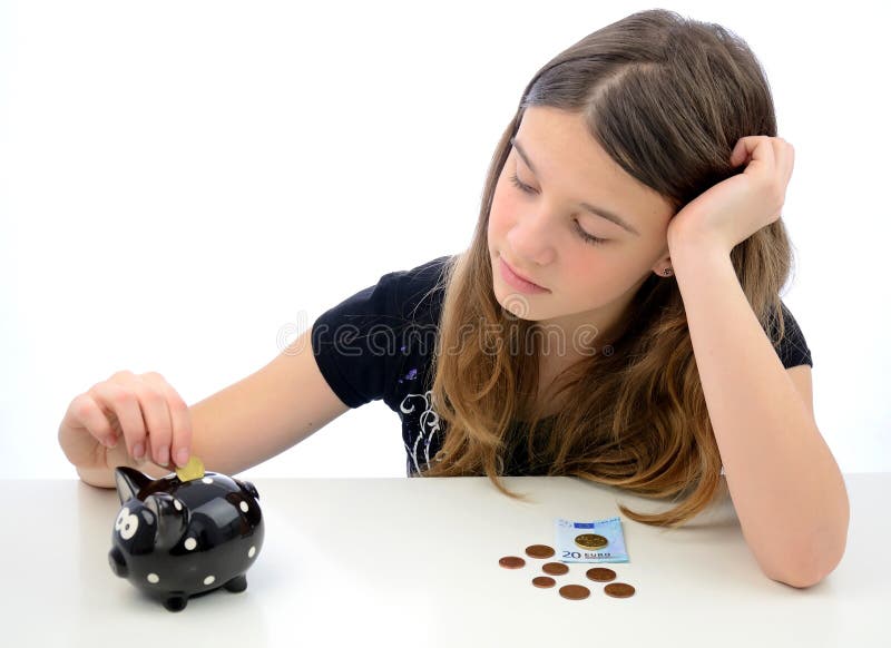 Teenager making euro money savings. Portrait of teenager laying diverse euro money in to the piggy-bank stock images