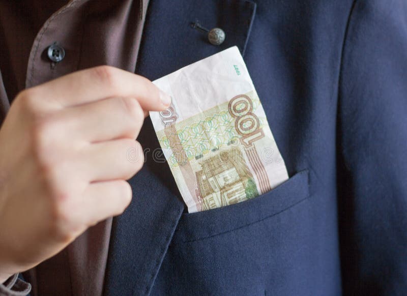 Teenager puts money in his pocket, pocket money, money for school lunch.  stock photo