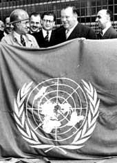 Building and administrative personnel hold the United Nations flag