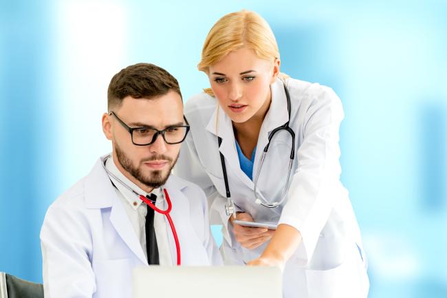 Немецкий врач с помощницей смотрят в компьютер